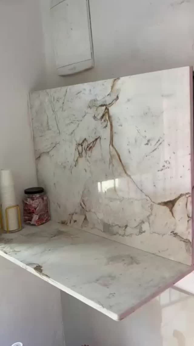 Bancada e frontão em mármore branco com veios dourados e marrons, acabamento polido